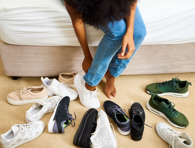 So many shoes, only two feet Cropped shot of a woman trying on different pairs of shoes
